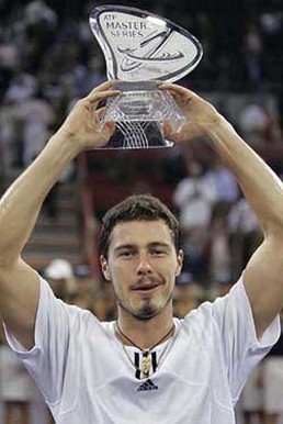 Marat Safin with very short hair holding a glass trophy
