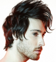 Men trendy hairstyle with long light punky bangs with layers and medium hair length with light wavies.PNG