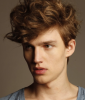 Cool men layered hairstyle with long wavy bangs and short hair length in the back.PNG