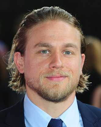 Picture of Charlie Hunnam image with medium layered haircut with bang pulled to the back
