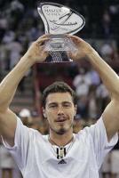 Marat Safin with very short hair holding a glass trophy