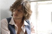 sexy medium curly hairstyle for man with very long side bangs.jpg