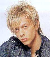 Medium layered and spiky hair style with long sidepart bangs, blonde
